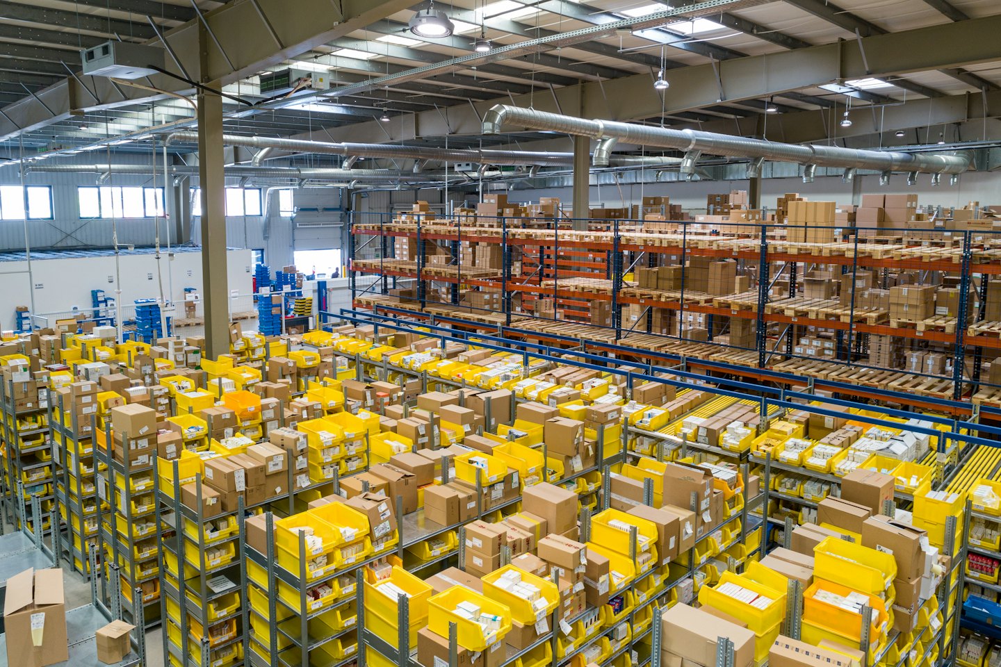Estantes llenos de cajas de cartón y contenedores amarillos.